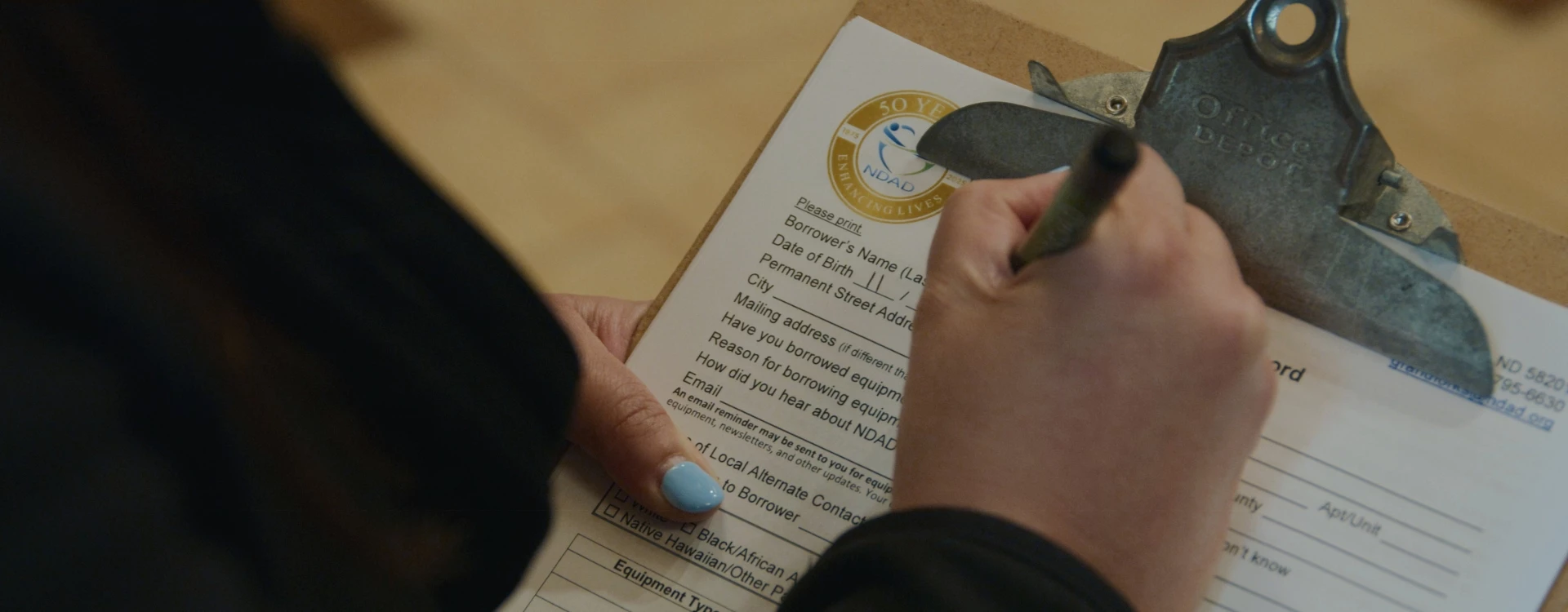 hand filling out application packet