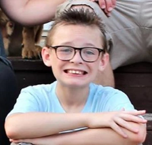 Young Braydon Kauzlarich sits with arms crossed over his legs.